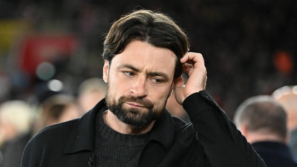 Rangers manager Russell Martin scratches his head with a concerned expression.