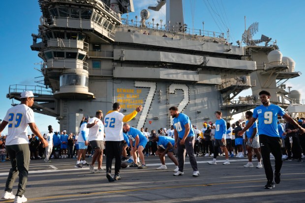 On the flight deck of the USS Abraham Lincoln (CVN 72) at NAS North Island in Coronado, CA, on Tuesday, July 22, 2025, the Los Angeles Chargers offense lines up against the defense. The Navy and NFL come together to kick off the countdown of the big celebration the city will have in late Oct. when the Navy and the Marines celebrate their 250th anniversary. (Nelvin C. Cepeda / The San Diego Union-Tribune)