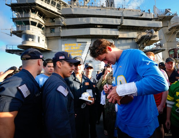 On the flight deck of the USS Abraham Lincoln (CVN 72) at NAS North Island in Coronado, CA, on Tuesday, July 22, 2025, Los Angeles Chargers quarterback Justin Herbert signs autographs for the crew members of the USS Lincoln.   (Nelvin C. Cepeda / The San Diego Union-Tribune)