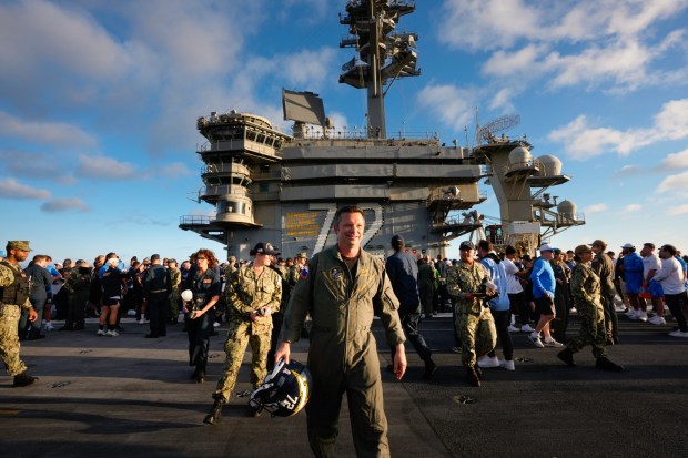 Cpt. Daniel Keeler, Commanding Officer of the USS Abraham Lincoln (CVN 72), walks the flight deck carrying an LA Chargers helmet with the number 72.  (Nelvin C. Cepeda / The San Diego Union-Tribune)