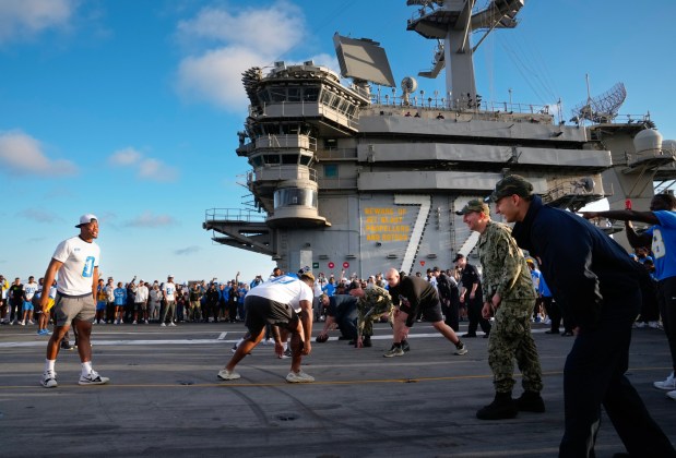 On the flight deck of the USS Abraham Lincoln (CVN 72) at NAS North Island in Coronado, CA, on Tuesday, July 22, 2025, the Los Angeles Chargers defense lines up against sailors from the USS Lincoln who are filling in as the offense. The Navy and NFL come together to kick off the countdown of the big celebration the city will have in late Oct. when the Navy and the Marines celebrate their 250th anniversary. (Nelvin C. Cepeda / The San Diego Union-Tribune)
