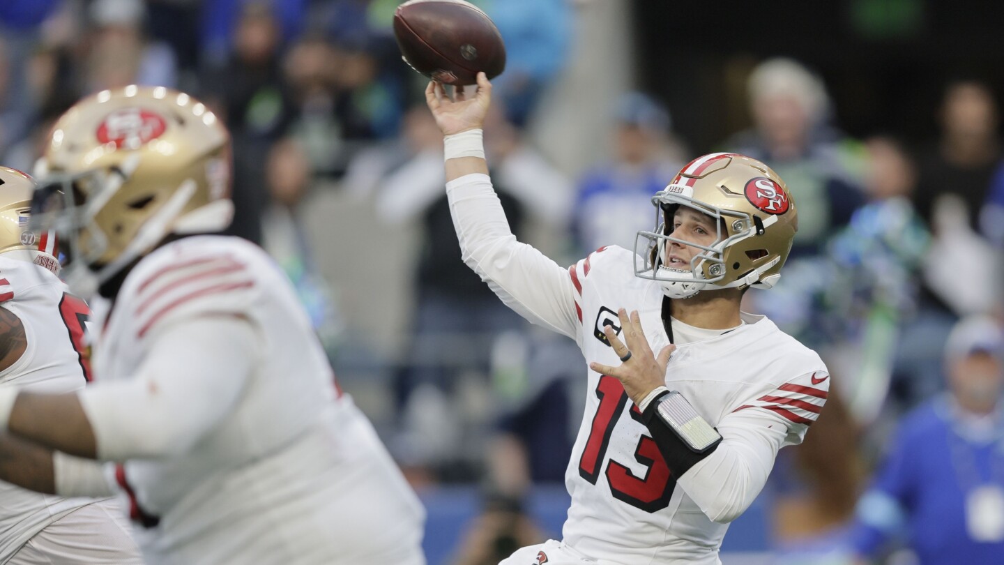 Brock Purdy throws for 3 TDs and the 49ers beat the Seahawks 36-24 to move atop division