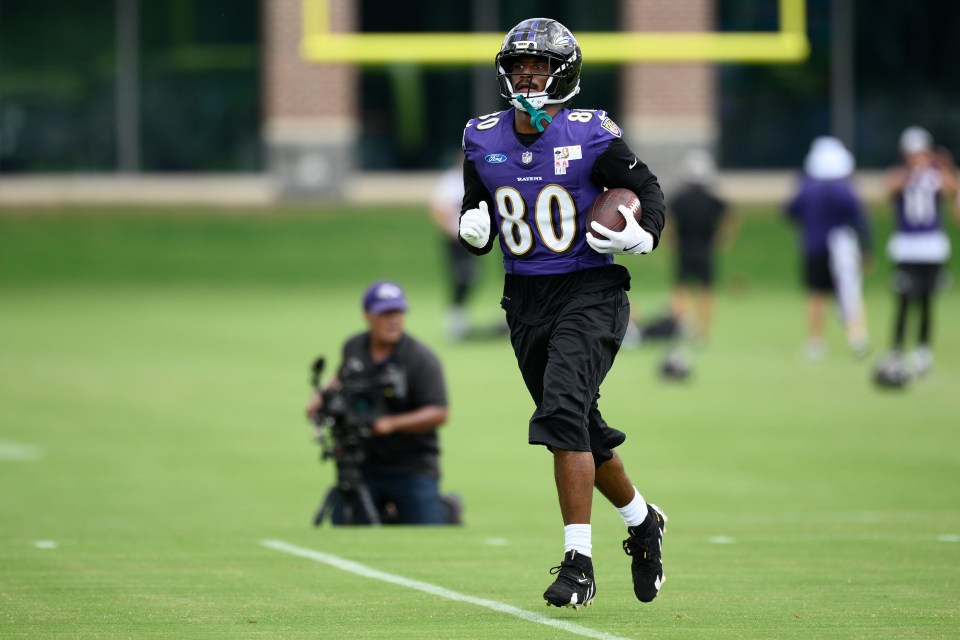 Baltimore Ravens tight end Isaiah Likely (80) running with a football during practice.