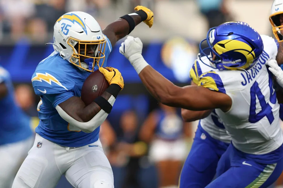 Chargers running back Raheim Sanders, left, tries to fend off Rams linebacker Brennan Jackson.
