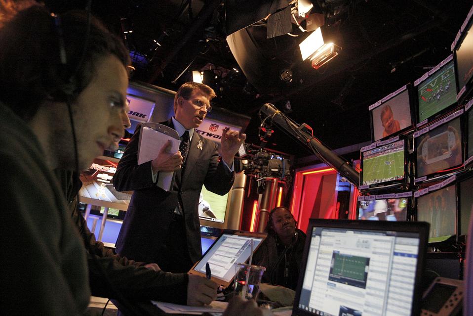 Scott Hanson (middle), lead anchor for the NFL RedZone network, is photographed during the Sunday b
