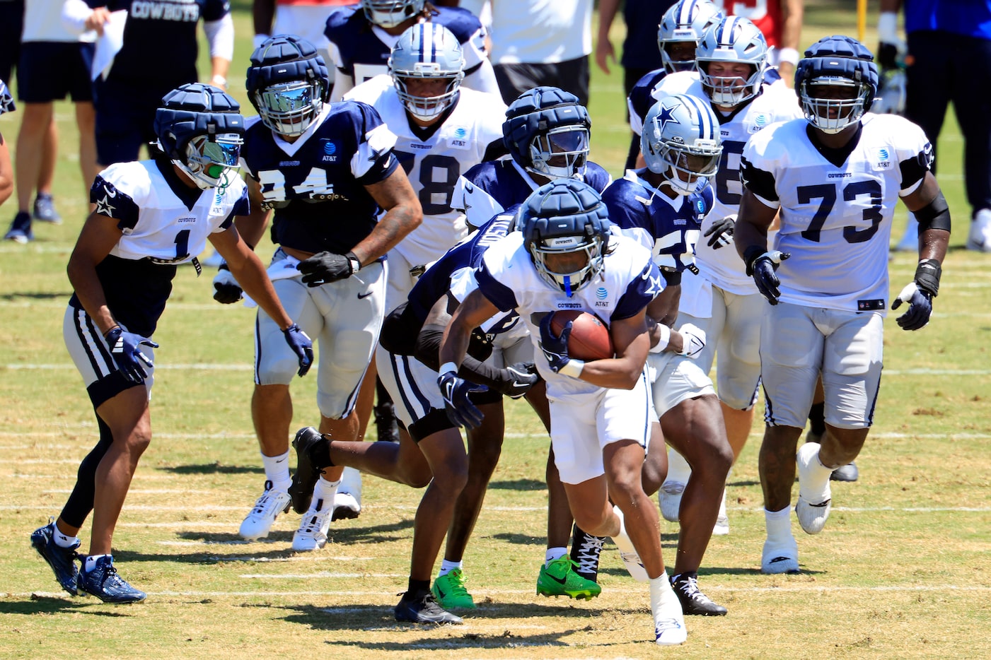 Dallas Cowboys running back Jaydon Blue (34) is tackled by defenders as he carries the...