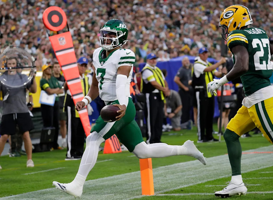 New York Jets quarterback Justin Fields (7) scores a touchdown against Green Bay Packers safety Kitan Oladapo (27) during their football game Saturday, August 9, 2025, at Lambeau Field in Green Bay, Wisconsin.