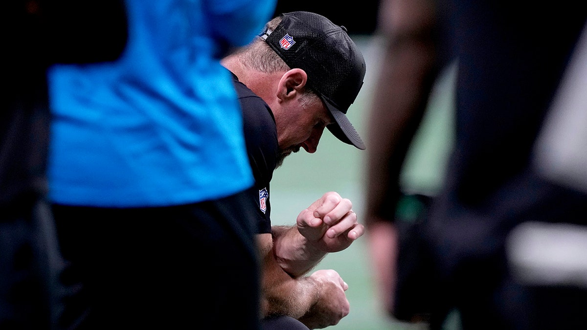 Dan Campbell kneels