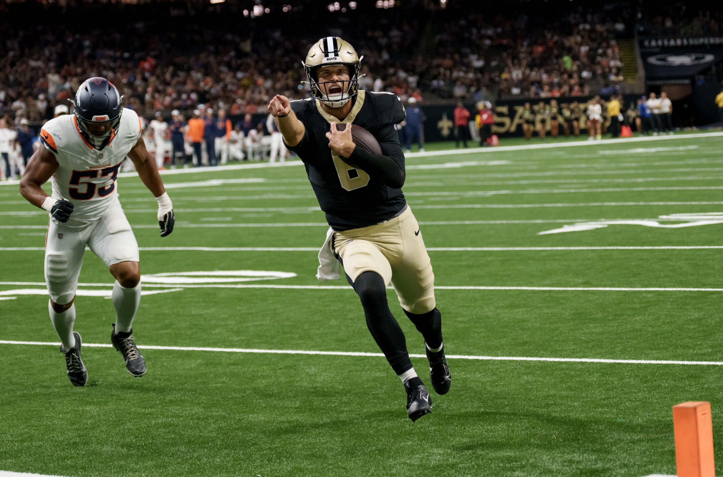 Aug 23, 2025; New Orleans, Louisiana, USA; New Orleans Saints quarterback Tyler Shough (6) runs in for a touchdown against Denver Broncos linebacker Andrew Farmer (53) during the fourth quarter at Caesars Superdome. Mandatory Credit: Matthew Hinton-Imagn Images