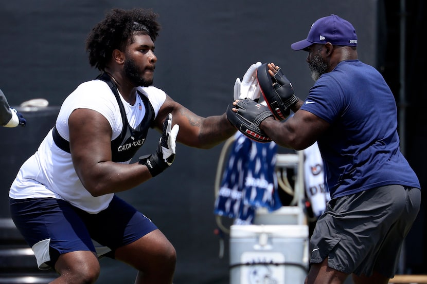 Dallas Cowboys guard Tyler Booker (left) works on his technique following a training camp...