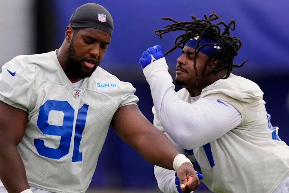 Rams defensive tackle Kobie Turner, left, and defensive tackle Ty Hamilton run a drill during practice in May.