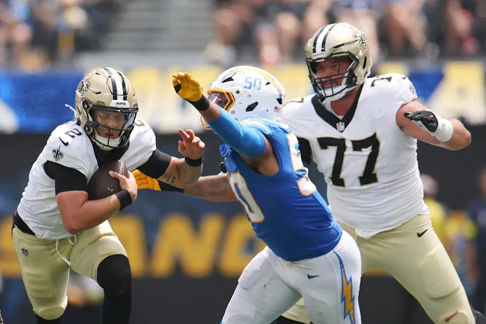 New Orleans Saints quarterback Spencer Rattler is tackled by Chargers linebacker Caleb Murphy.