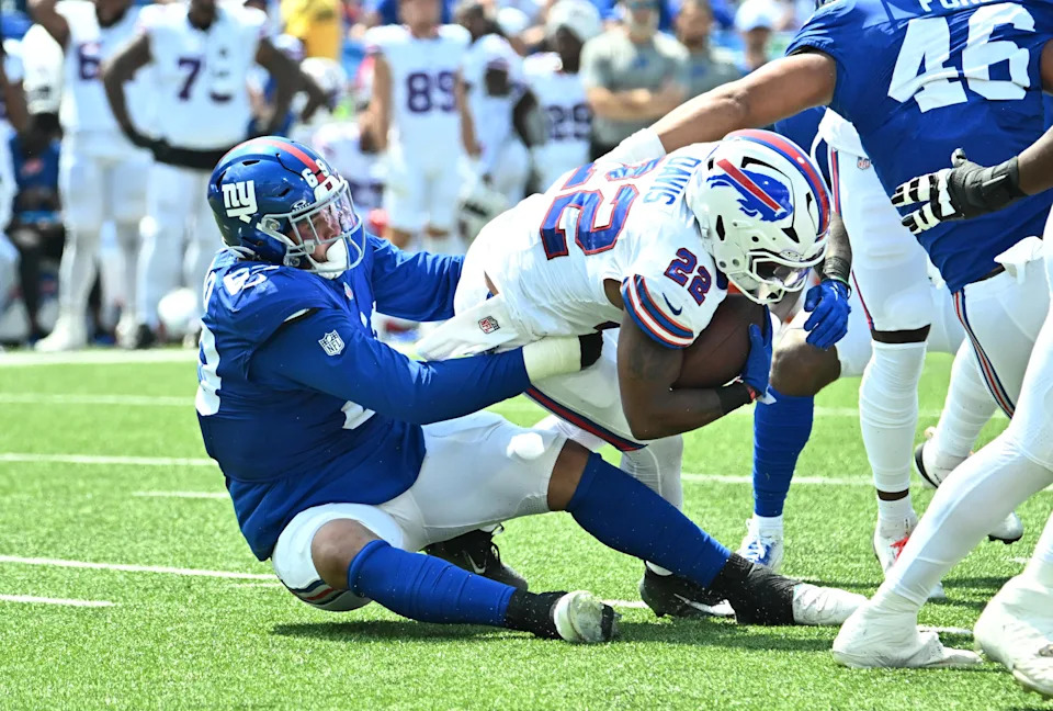 Aug 9, 2025; Orchard Park, New York, USA; New York Giants defensive tackle Cory Durden (69) makes a tackle on Buffalo Bills running back Ray Davis (22) in the second quarter at Highmark Stadium. Mandatory Credit: Mark Konezny-Imagn Images