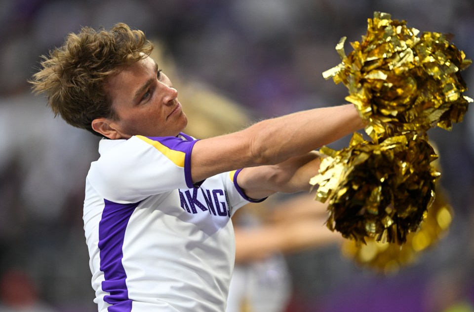 Minnesota Vikings cheerleader with gold pom-poms.