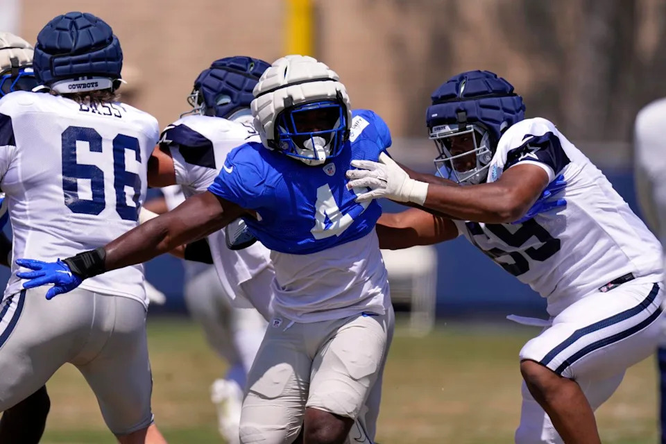 Dallas Cowboys offensive tackle Ajani Cornelius, right, tries to hold back Rams linebacker Josaiah Stewart.