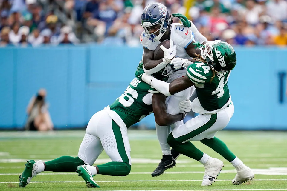 Tennessee Titans running back Tyjae Spears (2) is tackled by New York Jets linebacker Quincy Williams (56) linebacker Jamien Sherwood (44) during the second quarter at Nissan Stadium in Nashville, Tenn., Sunday, Sept. 15, 2024.