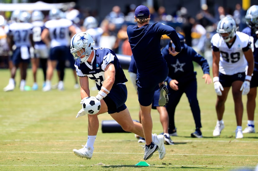 Dallas Cowboys linebacker Jack Sanborn (57) blocks a soccer ball kicked by a staff member as...
