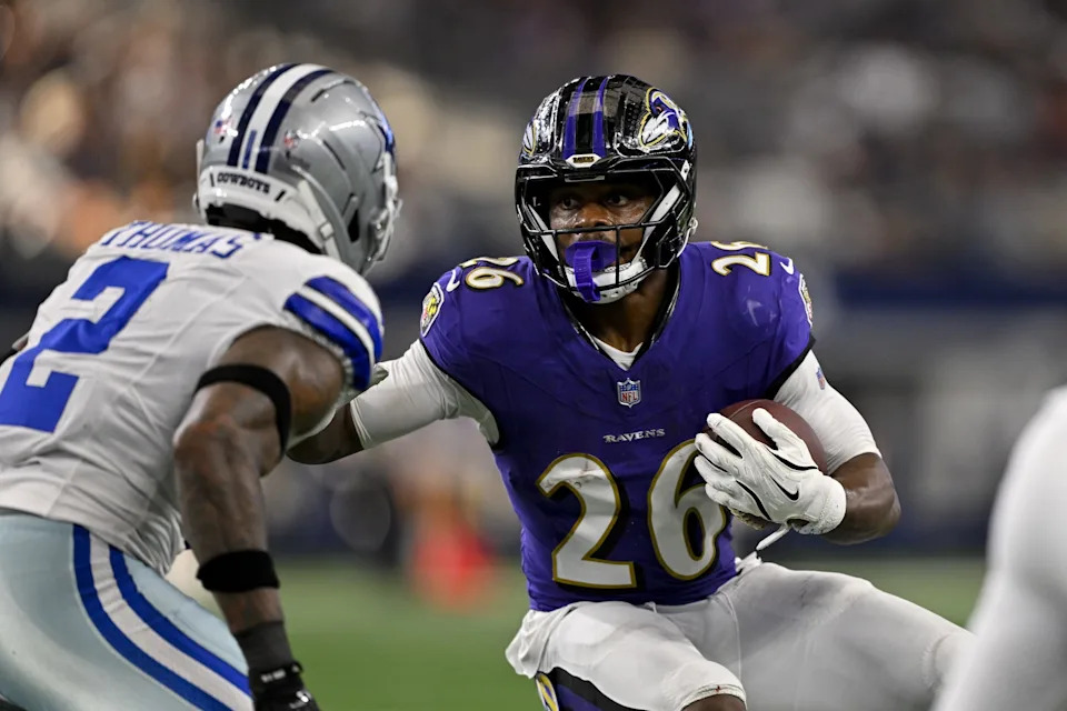 Aug 16, 2025; Arlington, Texas, USA; Baltimore Ravens running back Rasheen Ali (26) attempts to elude Dallas Cowboys safety Juanyeh Thomas (2) during the first quarter at AT&T Stadium. Mandatory Credit: Jerome Miron-Imagn Images