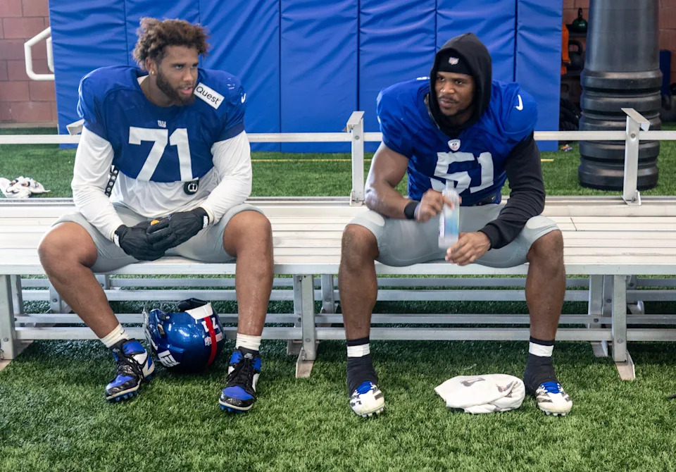 New York Giants guard Marcus Mbow (71) and linebacker Abdul Carter (51) wait for their turn to be interviewed after a joint training camp practice with the New York Jets, Wednesday, August 13, 2025, in East Rutherford, N.J.