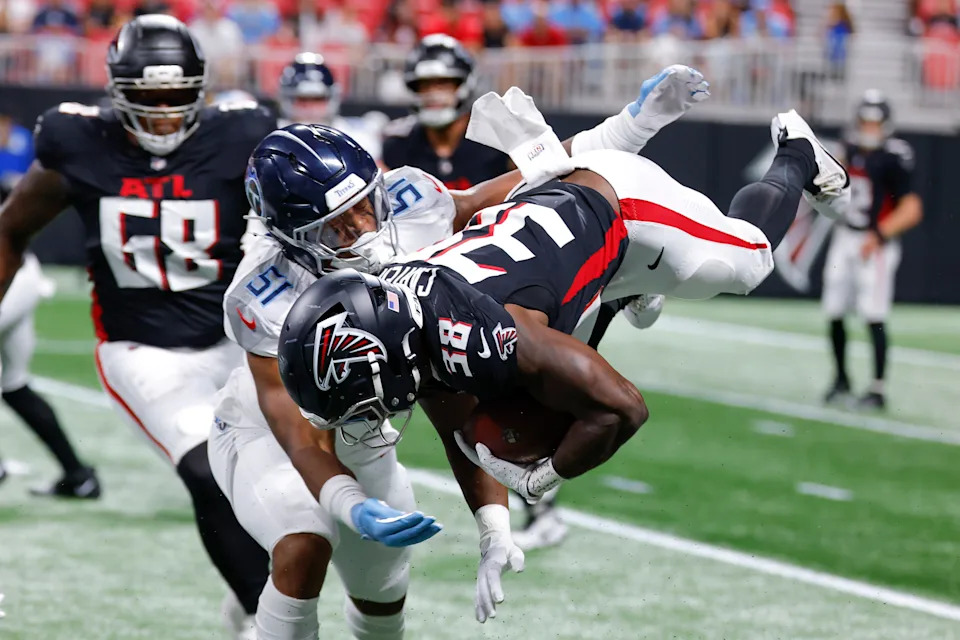 ATLANTA, GEORGIA - AUGUST 15: Nathan Carter #38 of the Atlanta Falcons is tackled by Cedric Gray #51 of the Tennessee Titans during the first half of the NFL Preseason 2025 game between Tennessee Titans and Atlanta Falcons at Mercedes-Benz Stadium on August 15, 2025 in Atlanta, United States. (Photo by Todd Kirkland/Getty Images)