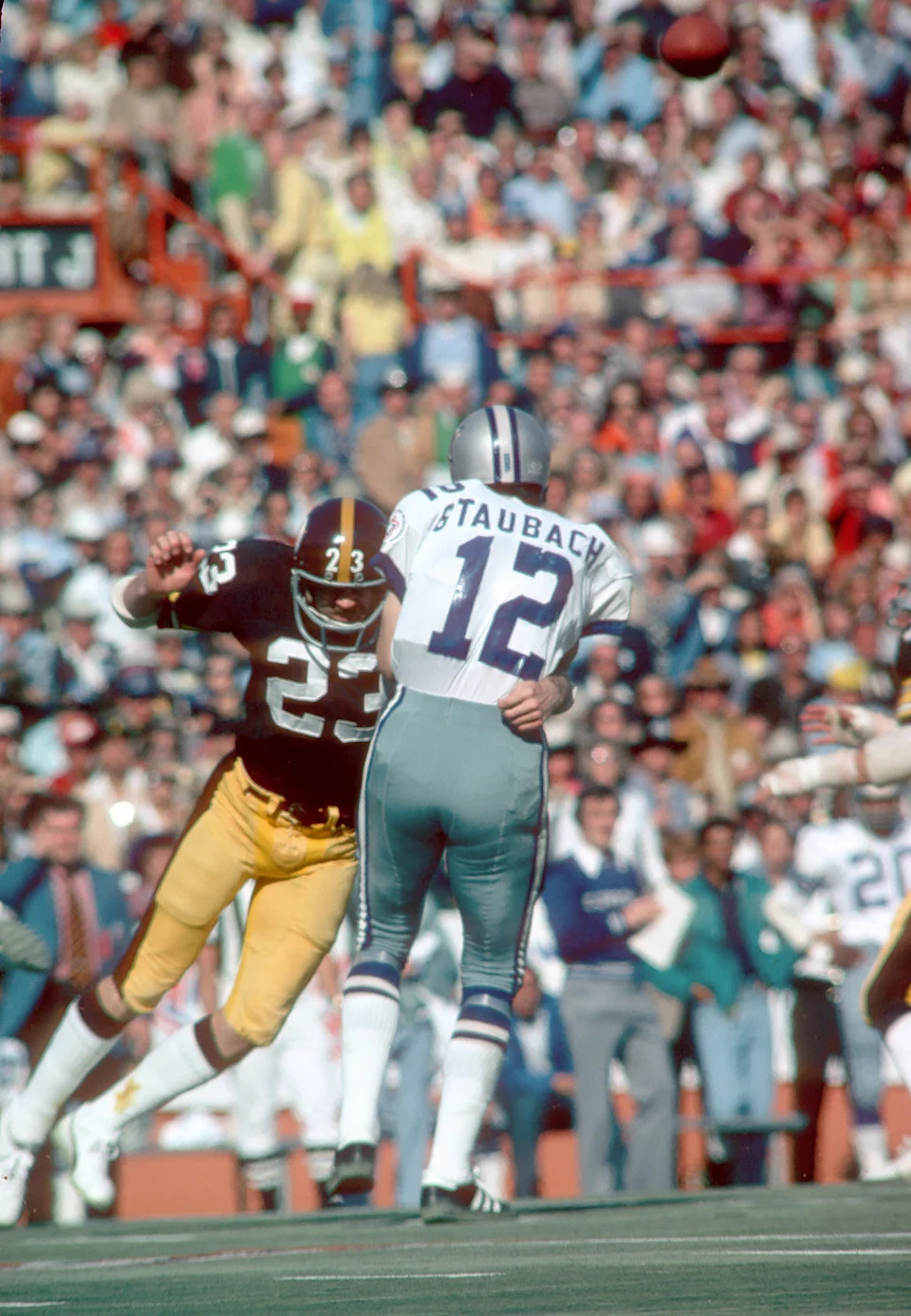 Jan 18, 1976; Miami, FL, USA; Dallas Cowboys quarterback Roger Staubach (12) is pressured by Pittsburgh Steelers safety Mike Wagner (23) during Super Bowl X at the Orange Bowl. Pittsburgh defeated the Cowboys 21-17. Mandatory Credit: Tony Tomsic-USA TODAY Sports