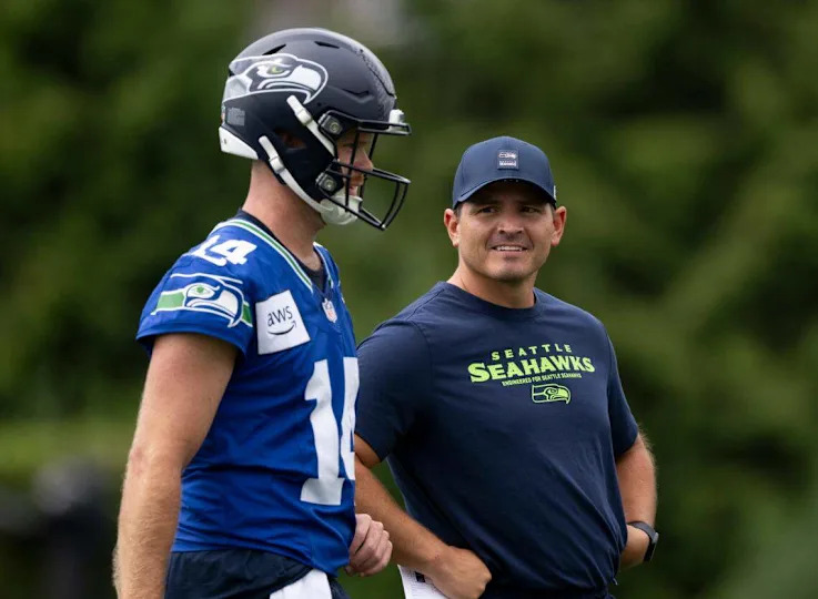 Seattle Seahawks quarterback Sam Darnold (14) and head coach Mike Macdonald talk during training camp at Virginia Mason Athletic Center on Friday, July 25, 2025, in Renton, Wash.