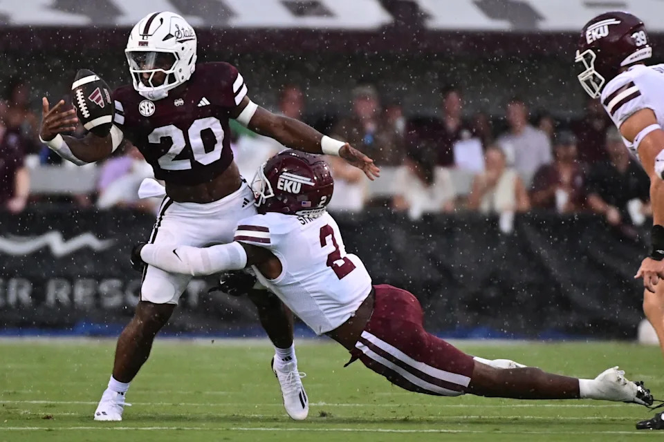 Aug 31, 2024; Starkville, Mississippi, USA; Mississippi State Bulldogs running back Johnnie Daniels (20) loses the ball as he is tackled by Eastern Kentucky Colonels defensive back Mike Smith Jr. (2) during the first quarter at Davis Wade Stadium at Scott Field. Mandatory Credit: Matt Bush-USA TODAY Sports