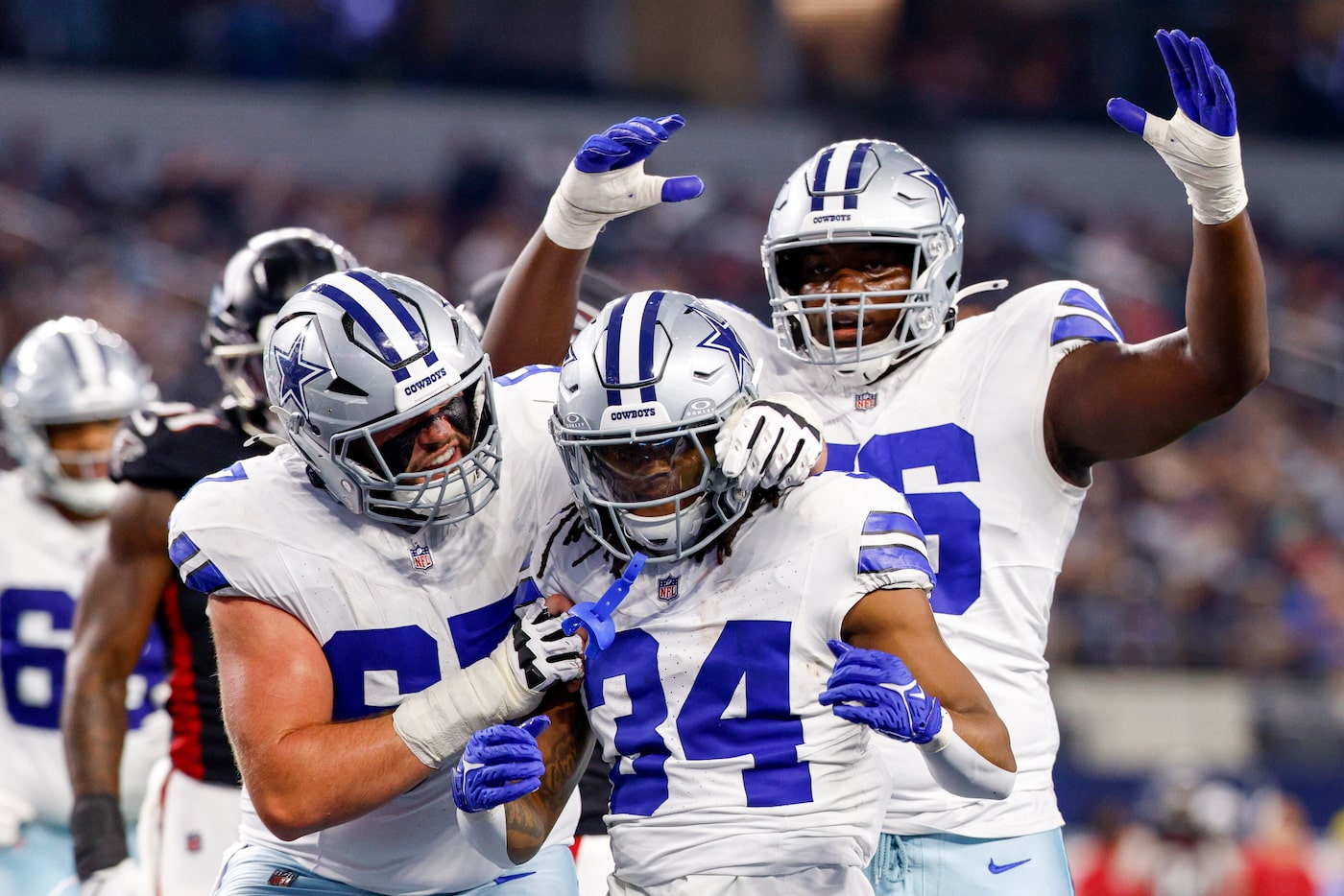 Dallas Cowboys running back Jaydon Blue (34) celebrates a touchdown with center Brock...