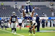 Dallas Cowboys quarterback Joe Milton (10) does a back flip as the team warmups before a NFL...