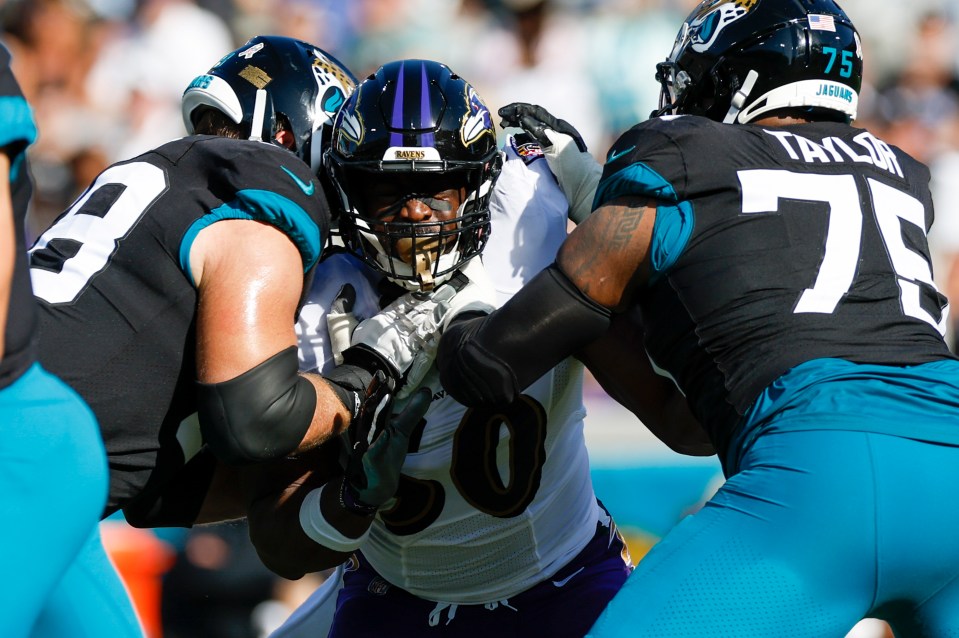 Photo of a Baltimore Ravens linebacker tackling Jacksonville Jaguars offensive linemen.