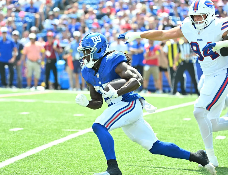 Aug 9, 2025; Orchard Park, New York, USA; New York Giants running back Dante Miller (25) runs past Buffalo Bills defensive end Landon Jackson (94) in the second quarter at Highmark Stadium. Mandatory Credit: Mark Konezny-Imagn Images