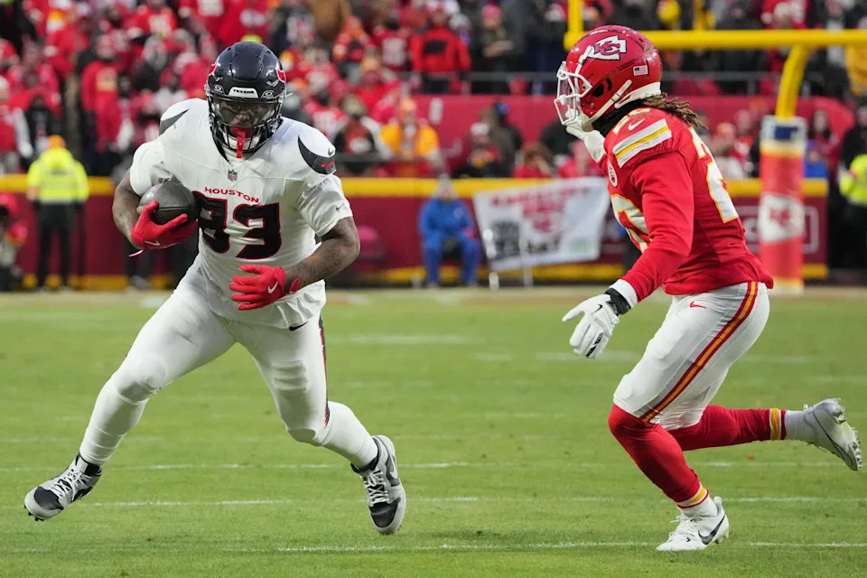 Jan 18, 2025; Kansas City, Missouri, USA; Houston Texans tight end Irv Smith Jr. (83) runs the ball against Kansas City Chiefs safety Justin Reid (20) during the 2025 AFC divisional round game at Arrowhead Stadium. Mandatory Credit: Denny Medley-Imagn Images
