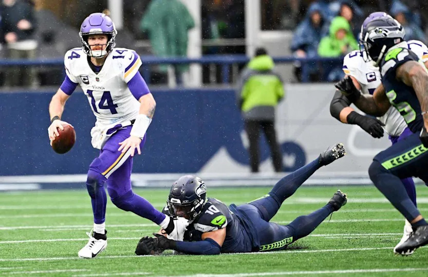 Minnesota Vikings quarterback Sam Darnold (14) evades Seattle Seahawks linebacker Uchenna Nwosu (10) during the first quarter of the first quarter of the game at Lumen Field, on Sunday, Dec. 22, 2024, in Seattle, Wash. Brian Hayes/bhayes@thenewstribune.com