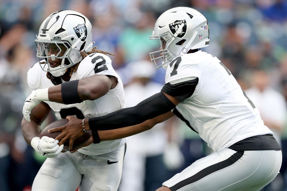 Geno Smith handing off the ball to Ashton Jeanty.