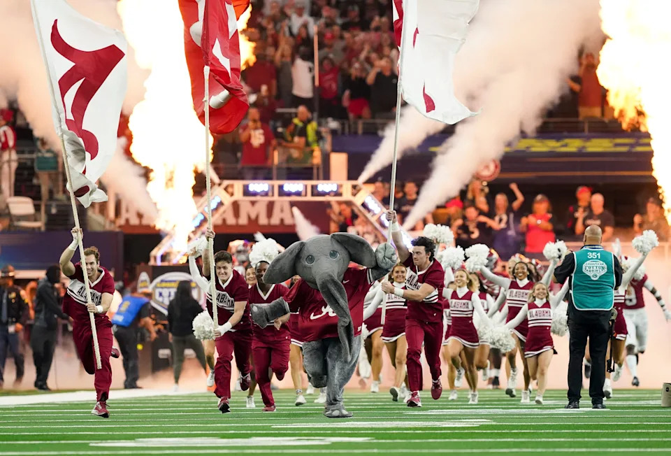 Big Al and the Alabama cheerleaders lead the Crimson Tide onto the field before the 2021 College Football Playoff Semifinal game at the 86th Cotton Bowl in AT&T Stadium in Arlington, Texas Friday, Dec. 31, 2021. Alabama defeated Cincinnati 27-6 to advance to the national championship game. [Staff Photo/Gary Cosby Jr.]