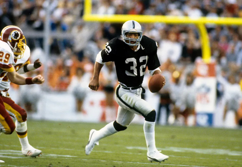 Jan 30, 1983; Pasadena, CA, USA; FILE PHOTO; Los Angeles Raiders running back Marcus Allen (32) carries the ball against the Washington Redskins during Super Bowl XVIII at Tampa Stadium. The Raiders defeated Redskins 38-9. Mandatory Credit: Manny Rubio-USA TODAY Sports