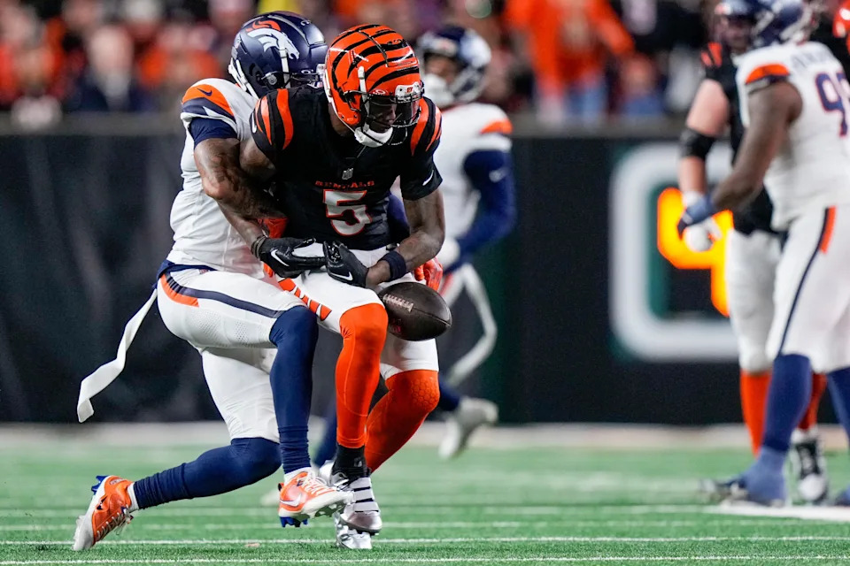 Cincinnati Bengals wide receiver Tee Higgins (5) fumbles a catch as he is wrapped up by Denver Broncos cornerback Pat Surtain II (2) in the fourth quarter of the NFL Week 17 game between the Cincinnati Bengals and the Denver Broncos at Paycor Stadium in downtown Cincinnati on Saturday, Dec. 28, 2024. The Bengals took a 30-24 win in overtime to remain in the post season chase.