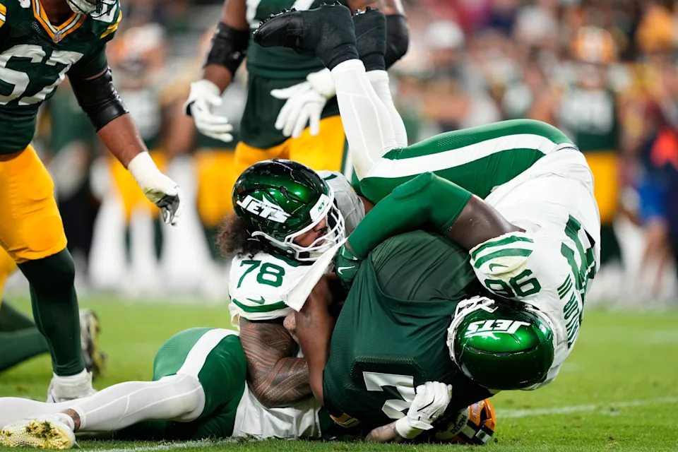 Aug 9, 2025; Green Bay, Wisconsin, USA; Green Bay Packers quarterback Malik Willis (2) is sacked by New York Jets defensive end Braiden McGregor (bottom), New York Jets defensive tackle Jay Tufele (78), and New York Jets defensive tackle Leonard Taylor III (96) during the second quarter at Lambeau Field. Mandatory Credit: Kayla Wolf-Imagn Images
