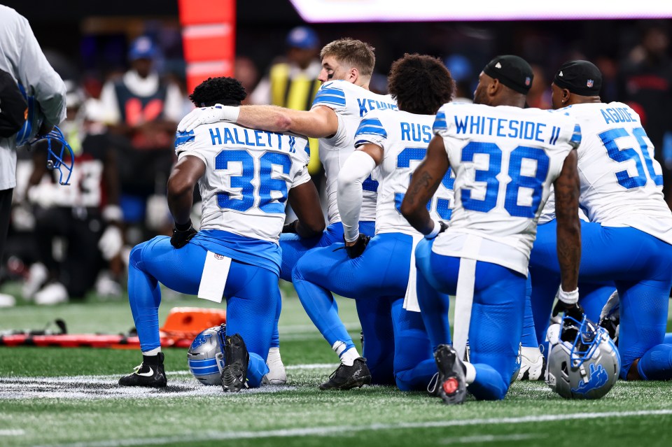 Detroit Lions players kneeling on the field.