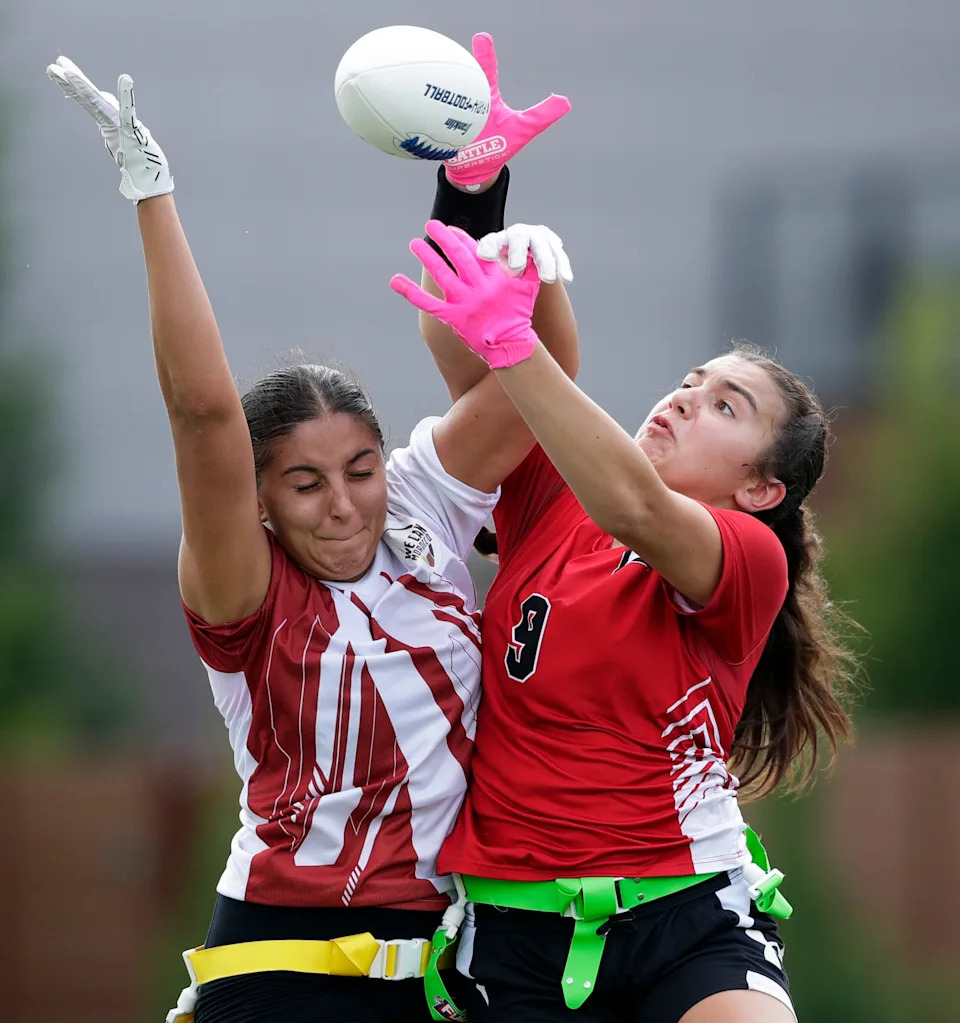 Green Bay East's Emma Beyer (9) goes up for the ball against We Can Morocco's Sonia Mouimen (4) during a girls flag football scrimmage on Aug. 7 at Green Bay Packers' Titletown district in Ashwaubenon.