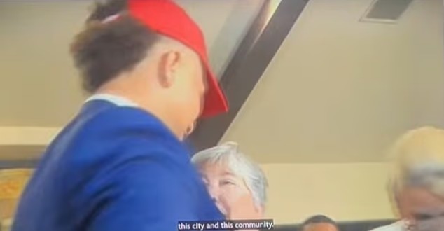 Person in a red hat embracing a woman.