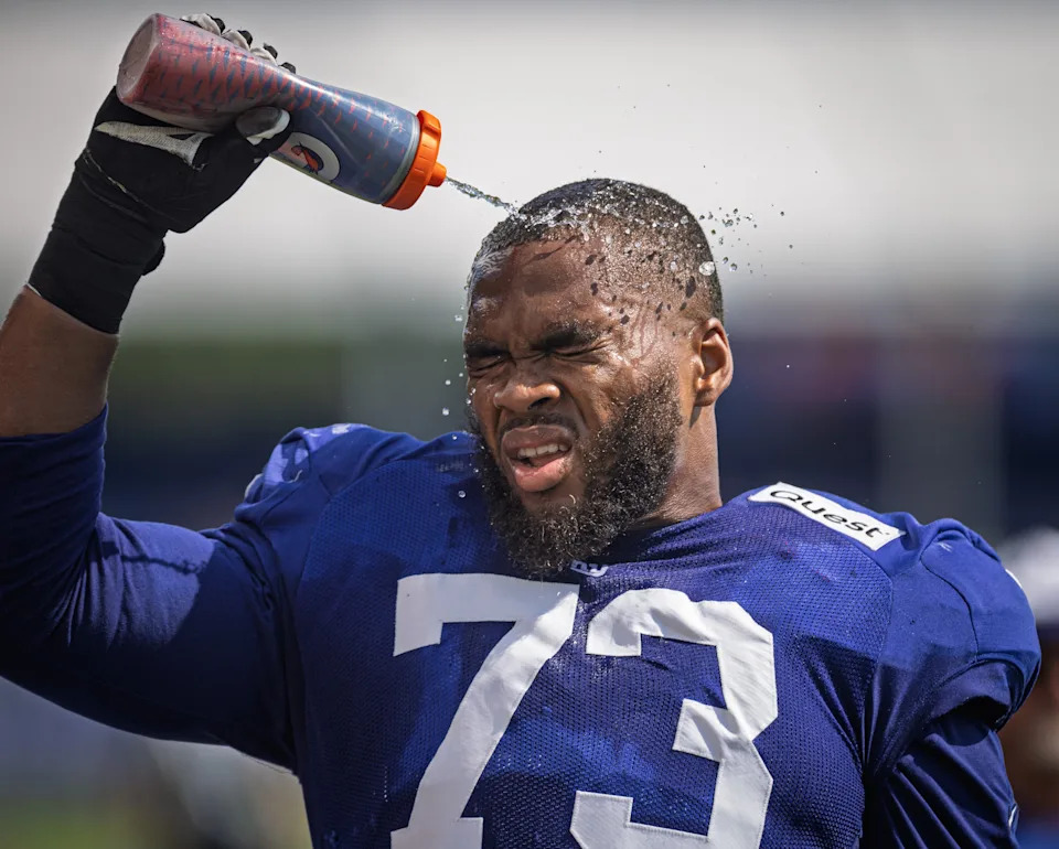New York Giants offensive tackle Evan Neal (73) cools off during a joint training camp practice with the New York Jets, Wednesday, August 13, 2025, in East Rutherford, N.J.
