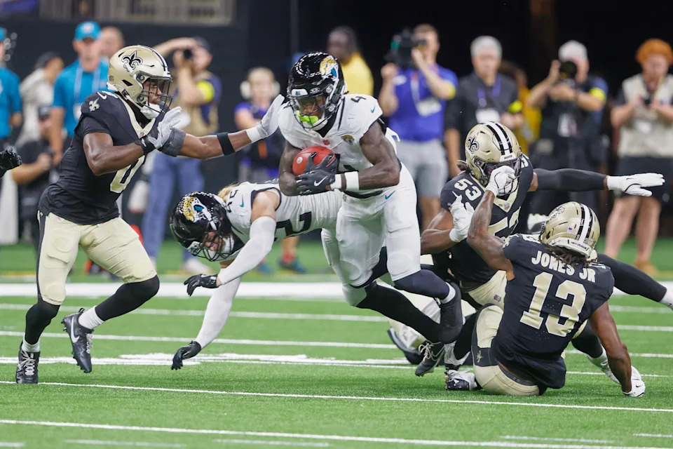 Jacksonville Jaguars running back Tank Bigsby (4) returns a kickoff as he tries to get past New Orleans Saints safety Ugo Amadi (0) in the first half of an NFL preseason football game in New Orleans, Sunday, Aug. 17, 2025. (AP Photo/Butch Dill)