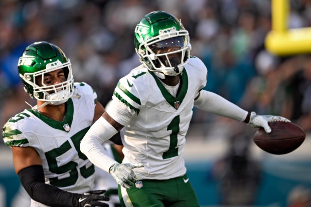 New York Jets cornerback Sauce Gardner (1) celebrates with linebacker Chazz Surratt (55) after Gardner intercepted a pass against the Jacksonville Jaguars during the second half of an NFL football game Sunday, Dec. 15, 2024, in Jacksonville, Fla. (AP Photo/Phelan M. Ebenhack)