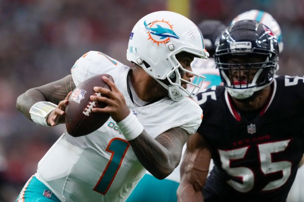 Miami Dolphins quarterback Tua Tagovailoa (1) runs the ball against Houston Texans defensive end Danielle Hunter (55) during an NFL football, game, Sunday, Dec. 15, 2024, in Houston. (AP Photo/Ashley Landis)