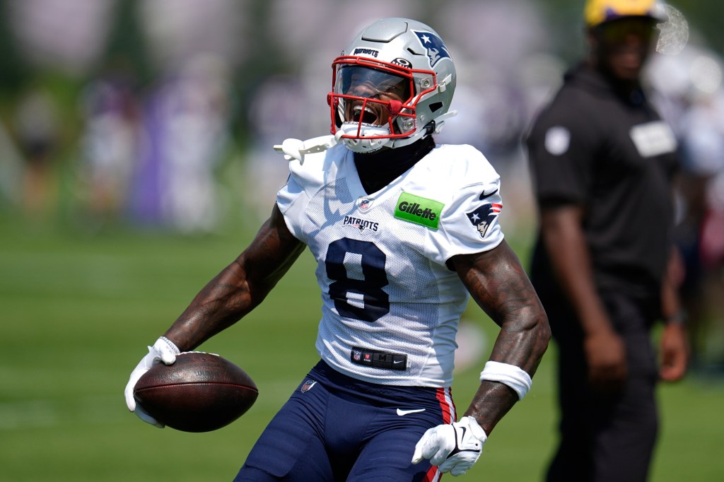New England Patriots player in uniform holding a football.
