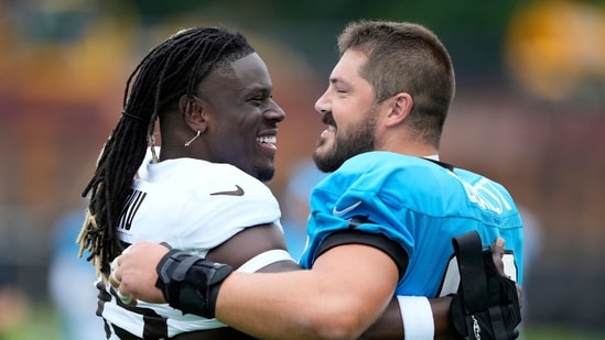 Cleveland Browns tight end David Njoku and Carolina Panthers center Austin Corbett hug during an NFL football dual training camp (AP)