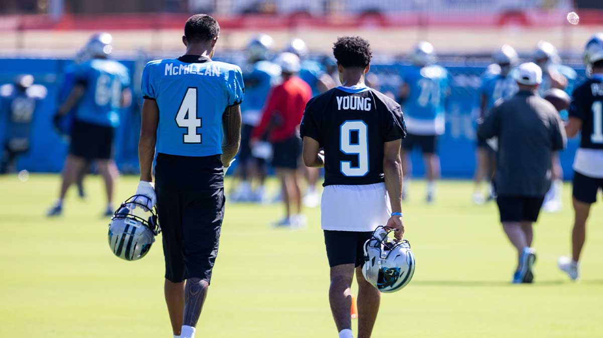 Carolina Panthers wide receiver Tetairoa McMillan (4) and quarterback Bryce Young (9) talk as they head to stretch during training camp.
