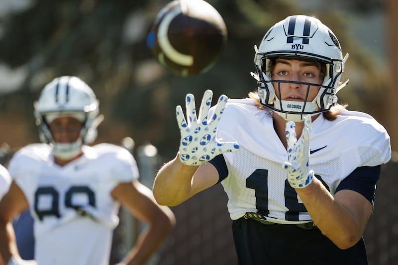 BYU receiver Reggie Frischknecht keeps his eye on the ball during fall camp practice in Provo.