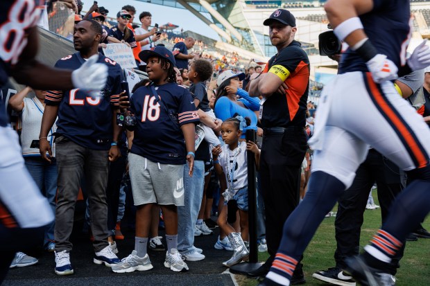 Fans watch Chicago Bears players take the field before the...
